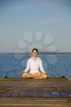 Yoga Woman on a dock by the ocean