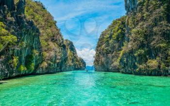 Tropical landscape - cristal clear water, rock islands, lonely boat