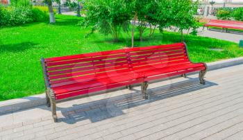 Old red wooden bench in city park