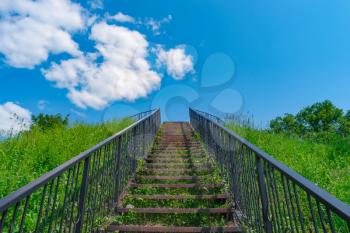 Stairway to heaven. Stairs among grass to blue sky.