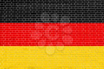 Flag of Germany on brick wall texture background. German national flag.