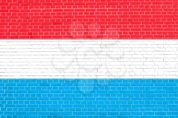 Flag of Luxembourg on brick wall texture background. Luxembourgish national flag.