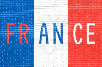 Flag of France on brick wall texture background. French national flag. Word France.