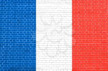 Flag of France on brick wall texture background. French national flag.