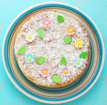 Sponge cake decorated with flowers and coconut