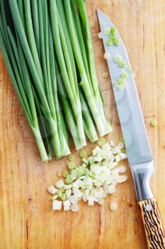 Chopped green onions on a wooden board