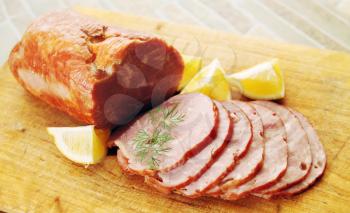 pork ham sliced ​​lemon on a wooden board