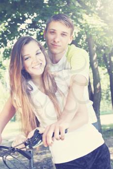 A young couple sitting on a bicycle