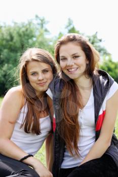 Two happy young girlfriends on the nature