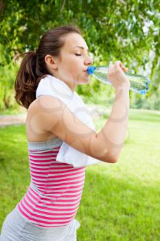 A woman drinks water from a bottle