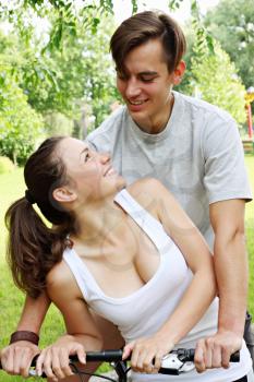 A young couple sitting on a bicycle