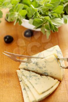 a large piece of blue cheese and black olives