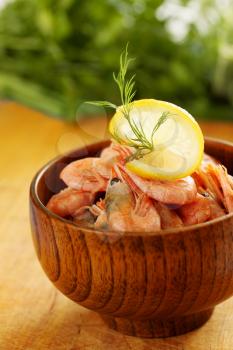 boiled shrimp with lemon and dill in a wooden bowl