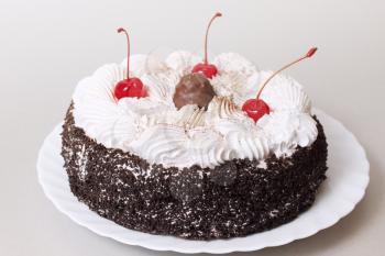 Celebratory chocolate cake with cherries and cream