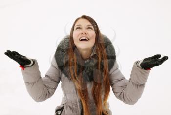  A young woman catches snowflakes in hand