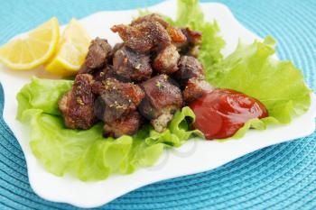 Spicy fried meat with fresh lettuce leaves