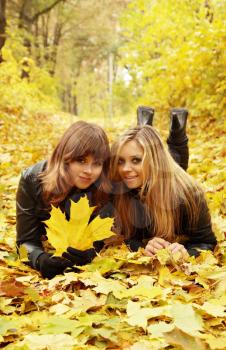 Two friends lying on the autumn leaves
