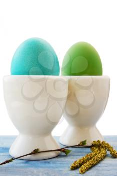 two eggs in a white ceramic stand on the board