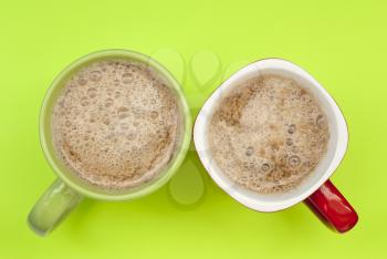 Two cups of coffee on a green background