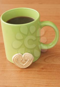 Cup of coffee and cookies in the shape of heart