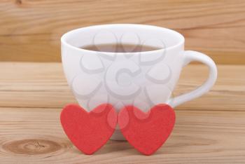 Cup of tea and two red hearts.