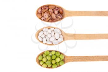Beans and green peas in a spoon on a white background.
