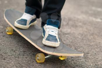 Skateboarder feet in sneakers on a skateboard.