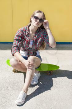 Stylish young girl with skateboard fun relaxing outdoors.