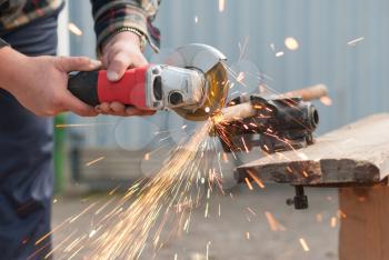 Man cuts a metal pipe power saw.