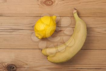 Lemon and bananas on a wooden background. View from above .