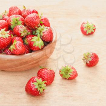 Old Wooden Bowl Filled With Succulent Juicy Fresh Ripe Red Strawberries On An Old Table top