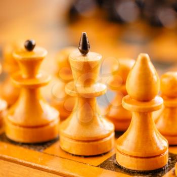 Chess standing on ancient wooden chessboard