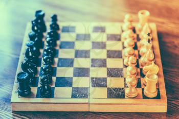 Chess standing on ancient wooden chessboard