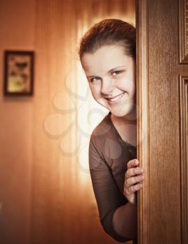 Beautiful Girl Peeking Behind The Door