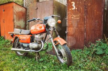 MINSK, BELARUS - SEPTEMBER 22, 2013: Old Red Russian (Soviet) Motorcycle Parked On Green Grass Yard. This motorcycles produced at Degtyarev plant in Russian town Kovrov since 1965.