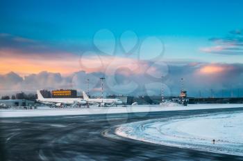 Aircraft stand on ground at International Airport terminal in early morning with beautiful sunrise dramatic sky.