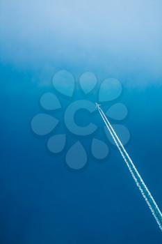 Contrail In Blue Sky. Plane, aircraft, airplane In Sky With Plane Trails. Copy space