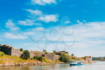 Tourist Boat Floats Near The Sea Fortress Of Suomenlinna. Historic Suomenlinna, Sveaborg Maritime Fortress In Helsinki, Finland. Sunny Day With Blue Sky