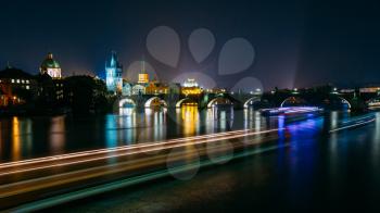 Night panorama of illuminated Charles Bridge in Prague, Czech Republic. Reflections of illumination in Vltava river.