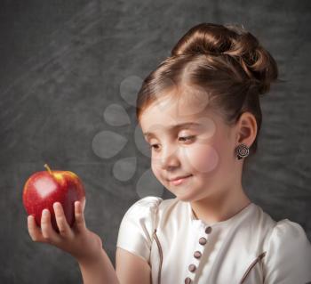 little girl holds red apple