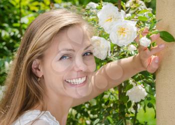 happy woman on a background of flowers with beautiful healthy teeth
