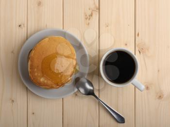 fresh pancakes with a cup of coffee on the wooden table