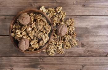 walnuts in the brown wooden bowl on table