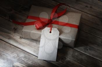 gift box with red ribbon and with a price tag on wooden table