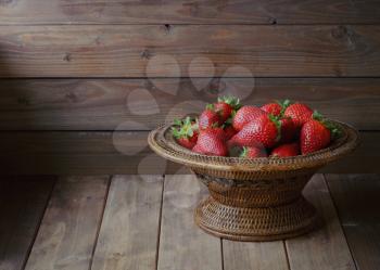 ripe strawberries in a bowl on wooden table