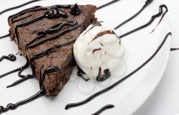 slice of cake brownie with ice cream on white plate