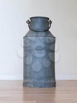 Old metal milk can on white background