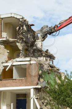 A crane is demolishing a block of flats