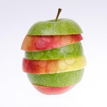 A sliced green and red apple isolated on a grey background