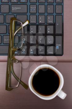 Espresso coffee with glasses on a laptop